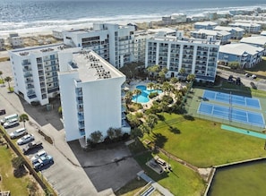 A coastal hotel complex with multiple buildings, a swimming pool, tennis courts, and a parking area. - Stunning 2 BR Condo - Bring your Boat to the Beach - GSSR 709A (Gulf Shores)