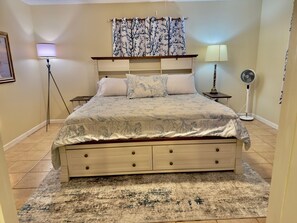 A bedroom with a bed, bedside tables, a lamp, a floor lamp, and a rug. - Private Pool • Game Room • Fire Pit • Boat Parking (Crystal River)