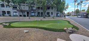 Ein Wohngebiet mit gepflegtem Rasen und einem Putting Green für Golf.