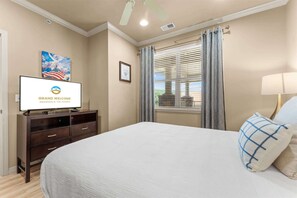 A hotel room with a bed, a television displaying the hotel's name, a window with blinds, and a painting on the wall. - Club Yakov & 3BDR Lakefront (Hollister)