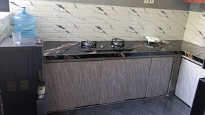 A kitchen with a marble backsplash, a built-in stove, and a water dispenser. - Umah Delod Dangin (Ubud)