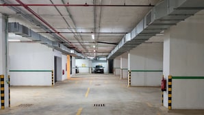 Eine mehrgeschossige Parkgarage mit deutlicher Beschilderung, darunter ein Ausgangsschild und ein Feuerlöscher.