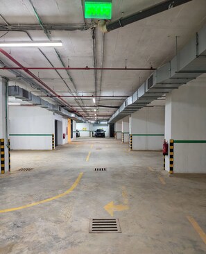 Eine mehrgeschossige Parkgarage mit deutlicher Beschilderung, darunter ein Ausgangsschild und ein Feuerlöscher.