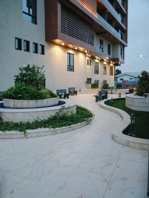 Een modern gebouw met een binnentuin, terras en een waterpartij.