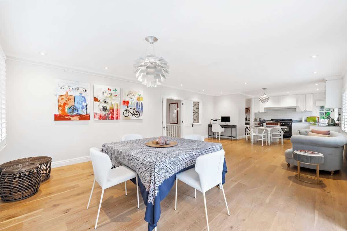 A modern living space with a dining area, kitchen, and seating area.
