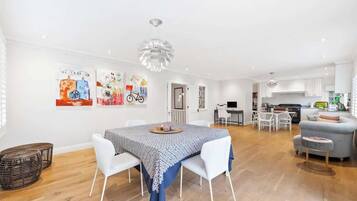 A modern living space with a dining area, kitchen, and seating area.
