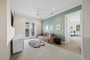 Ein Wohnzimmer mit Sofa, Couchtisch, Teppich und Deckenventilator.