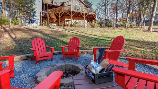 A fire pit area with red Adirondack chairs and a box of snacks. - Game Room  / Mtn Views  / Hot Tub / Fire Pit & Fire Table /  Coffee Bar / (Lake Lure)
