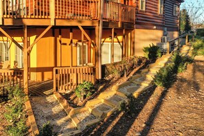 A log cabin with a wooden deck and a staircase leading to a second level. - Game Room  / Mtn Views  / Hot Tub / Fire Pit & Fire Table /  Coffee Bar / (Lake Lure)