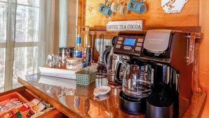 A coffee bar with a coffee machine, a coffee grinder, and a coffee press. There are mugs hanging on the wall and a sign that says 'Coffee Tea Cocoa'. - Game Room  / Mtn Views  / Hot Tub / Fire Pit & Fire Table /  Coffee Bar / (Lake Lure)