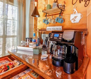 A coffee bar with a coffee machine, a coffee grinder, and a coffee press. There are mugs hanging on the wall and a sign that says 'Coffee Tea Cocoa'. - Game Room  / Mtn Views  / Hot Tub / Fire Pit & Fire Table /  Coffee Bar / (Lake Lure)