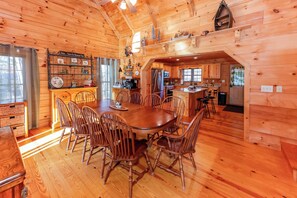 A wooden interior with a dining area, kitchen, and a cozy cabin-like atmosphere. - Game Room  / Mtn Views  / Hot Tub / Fire Pit & Fire Table /  Coffee Bar / (Lake Lure)