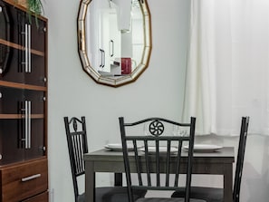 A dining area with a wooden table, black chairs, and a mirror on the wall. - Río Manzanares IV - Apartment Renovated (Ciudad de Madrid)