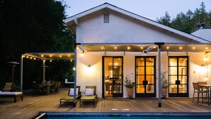 Ein Haus mit Pool, Sitzgelegenheiten im Freien und Lichterketten.