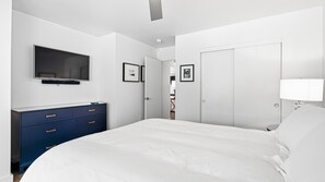 A bedroom with a bed, a TV mounted on the wall, a dresser, and a door leading to another room. - Private Pool | East Sonoma | By Homewood Winery | 2BR, Sleeps 4, Quiet Street (Sonoma)