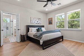 Ein Schlafzimmer mit Bett, Deckenventilator, Fenster und Tür.