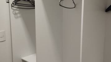 A white closet with shelves and a hanging rod.