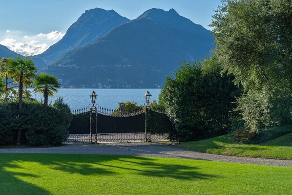 Uma entrada com portão e vista para um lago e montanhas.