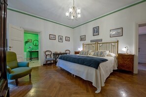 A bedroom with a bed, a chair, a table, and a green wall. - Villa Donzella - Luxury historic villa with pool (Menaggio)