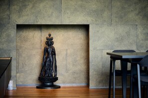 Eine Statue in einem Raum mit strukturierter Wand und Holzboden.