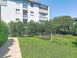 Ein modernes Gebäude mit gepflastertem Weg und üppiger Bepflanzung.