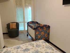 A bedroom with a bed, a chair, and a small table. - Onda Blu House by Interhome (Loano)