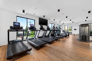 Ein Fitnessraum mit mehreren Laufbändern, einem Ergometer und einem Kraftgerät.