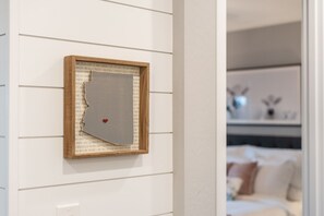 Une œuvre d’art encadrée, accrochée à un mur, et présentant une déchirure visible.