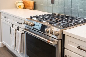 A kitchen with a stainless steel gas stove, oven, and a white countertop. - Desert Mountain Views - Quiet Retreat - Hot Tub - Firepit - Quiet Neighborhood (Goodyear)
