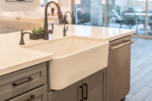 A kitchen with a white sink, grey cabinets, and a countertop. - Desert Mountain Views - Quiet Retreat - Hot Tub - Firepit - Quiet Neighborhood (Goodyear)
