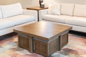 A modern living room with a wooden coffee table, two white sofas, and a patterned rug. - Desert Mountain Views - Quiet Retreat - Hot Tub - Firepit - Quiet Neighborhood (Goodyear)