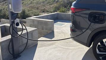 A car connected to a charging station in an outdoor setting.