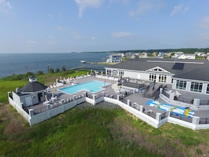 Un'ampia casa con piscina, patio coperto e vista sull'acqua.