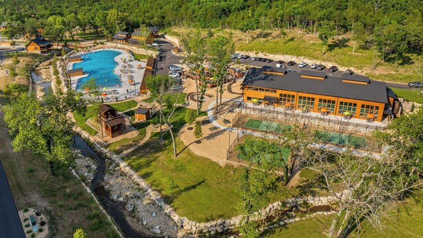 Een resort met een zwembad, een groot gebouw en een bergachtig achtergrond.