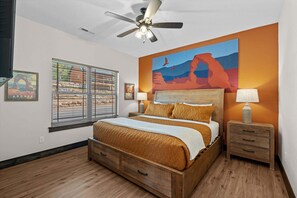 A bedroom with a bed, a nightstand, a lamp, a ceiling fan, and a window with blinds. - More than a getaway, your best Branson family vacation memories start right here! (Hollister)
