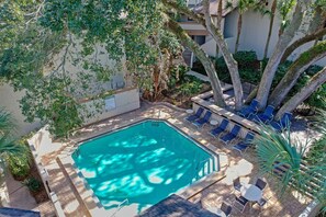 Ein rechteckiger Pool, umgeben von Liegestühlen und einer Holzterrasse.
