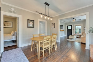 A spacious living room with a wooden dining table and chairs, a ceiling fan, and a view through a window. - Parkside 1922 - Steps to Boone Park & Avondale Shops (Jacksonville)