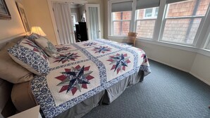 Ein Schlafzimmer mit Bett, Fenster und Tür.
