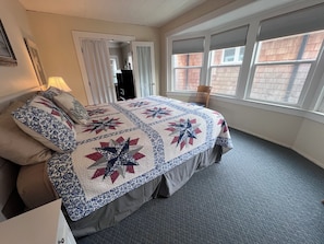 Ein Schlafzimmer mit Bett, Fenster und Tür.