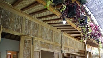 Un espacio de estar al aire libre cubierto, con sillas y plantas en macetas.