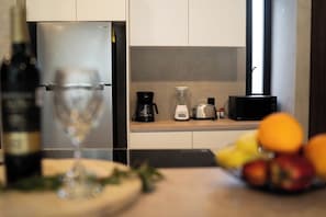 Eine moderne Küche mit einem Edelstahl-Kühlschrank, einer Kaffeemaschine, einem Toaster und einer Mikrowelle.