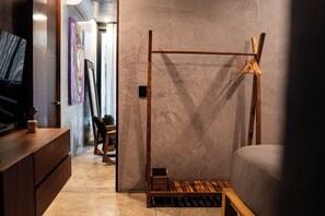 Une chambre à coucher moderne avec un cadre de lit en bois, un petit banc en bois et un téléviseur posé sur une commode en bois.