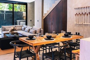 A dining area with a wooden table set for four, surrounded by black chairs. - Casa Naya - 2 Pools, Near Beach, VIP Concierge (Tulum)