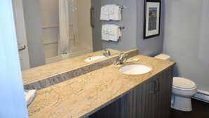 A bathroom with a double sink vanity, a shower, and a toilet. - Peak July Escape! Spacious 2BR Suite in the Heart of Victoria (Victoria)