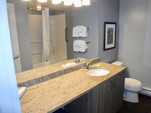 A bathroom with a double sink vanity, a shower, and a toilet. - Peak July Escape! Spacious 2BR Suite in the Heart of Victoria (Victoria)