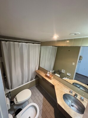 Une salle de bain avec des toilettes, un lavabo et un rideau de douche.