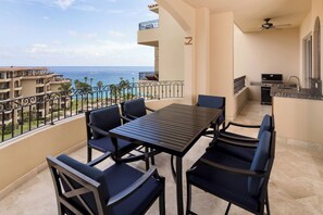 A balcony with a table and chairs, a ceiling fan, and a view of the ocean. - Newly Remodeled! No Lock Off-2BR at Estancia! Lavish furnishings, amenities and view! (Cabo San Lucas)