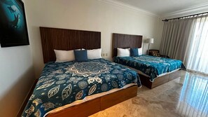 A hotel room with two beds, each with a patterned bedspread and wooden headboards. - BRAND NEW! Remodeled Full 2BR at Estancia! Lavish furnishings, amenities and view! (Cabo San Lucas)