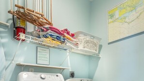 Une buanderie équipée de deux machines à laver, d’un étendoir et d’une carte accrochée au mur.