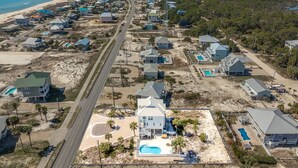 Une zone résidentielle côtière comprenant des maisons, une route et une plage.